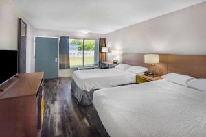 una camera d'albergo con due letti e una finestra di Days Inn by Wyndham Owensboro a Owensboro