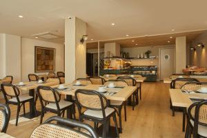 a restaurant with wooden tables and chairs and a kitchen at Sercotel Hotel Zurbarán Palma in Palma de Mallorca