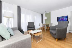 a living room with a couch and chairs and a table at Ferienwohnung Ankergold im Deichhaus in Bensersiel