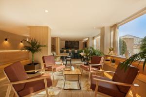 a lobby with chairs and tables and a living room at Sercotel Hotel Zurbarán Palma in Palma de Mallorca