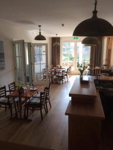 un comedor con mesas, sillas y ventanas en Herberg het Landhuis, en Schoorl