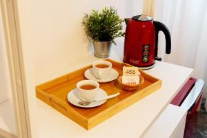 a tray with two cups of coffee and a tea kettle at Reale House Rooms in Rome