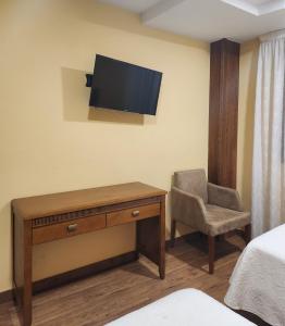 a room with a desk and a chair and a television at Saint James Way in Cacabelos