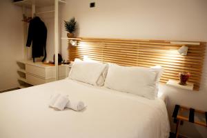 a white bed with a pair of towels on it at Reale House Rooms in Rome