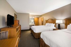 a hotel room with two beds and a flat screen tv at Revel Hotel Minot - SureStay Collection by Best Western in Minot