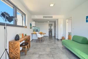 a living room with a green couch and a table at Villa Ming - pool, sea-view and peace in Slatine