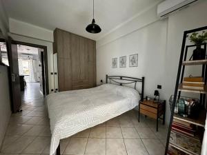 una camera con un letto bianco e una porta in legno di Iris Apartment Nafpaktos a Nafpaktos