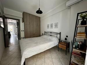 um quarto com uma cama branca e uma porta de madeira em Iris Apartment Nafpaktos em Lepanto