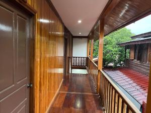 een hal van een huis met houten vloeren en een deur bij Xayana Home Villas in Luang Prabang