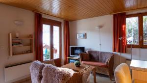 a living room with a couch and a chair and a television at Stachelbeere UG in Fiesch