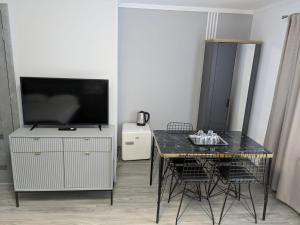 a dining room with a table and a television at Pension Casa Samurai in Braşov