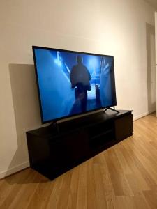 a flat screen tv sitting on a black entertainment center at Grand appartement lumineux in Noisy-le-Grand