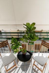 balcón con sillas, mesa y plantas en Sunny & Modern apt for 3 persons, en Atenas