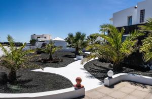 a view of a courtyard with palm trees and a building at Villa Canis in Tías