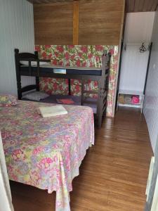 Dormitorio pequeño con cama con colcha de flores en Contconteiner hospedagem, en Olímpia
