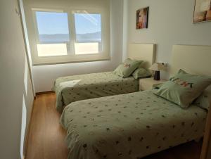 A bed or beds in a room at Apartamento 2 habitaciones con vistas en la playa