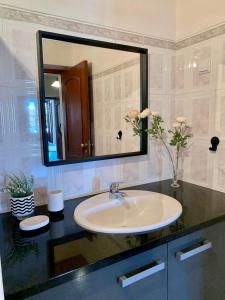 a bathroom with a sink and a large mirror at Casa do Rossio in Estremoz