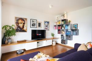 a living room with a blue couch and a tv at Home Away From Home in Radovljica