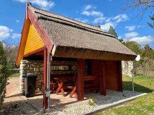 a log cabin with a roof and a picnic table at Bene Vendégház in Szigliget