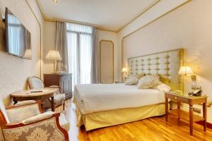 a hotel room with a large bed and a chair at Hotel Roger de Llúria in Barcelona +53 photos