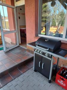 a grill sitting on top of a table in a patio at Dom z Sauną i Jacuzzi dla dwóch rodzin Siłownia Kajaki in Gołdap