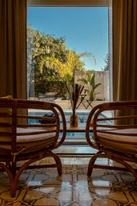 two wooden benches sitting in front of a window at The Carob Tree in Victoria