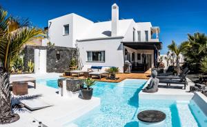 a villa with a swimming pool in front of a house at Villa Canis in Tías