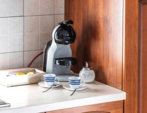 a coffee maker and two cups on a counter at Sa Perla Marina - FREE WIFI - 500 mt from the beach in Costa Rei