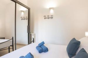 una camera da letto con letto, cuscini blu e specchio di Sa Perla Marina - FREE WIFI - 500 mt from the beach a Costa Rei