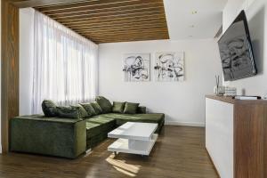 a living room with a green couch and a table at KOA - Memo Haus in Braşov