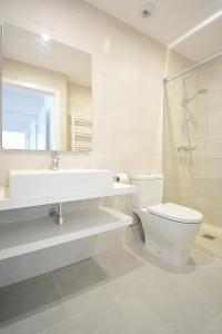 a bathroom with a sink and a toilet and a mirror at Precioso apartamento con piscina en Sanxenxo in Sanxenxo