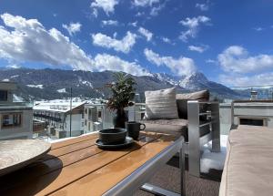 a balcony with a table and a view of mountains at Apartment BergRoof in Garmisch-Partenkirchen