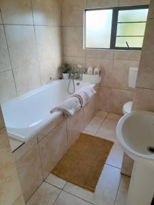 a bathroom with a tub and a sink at 625 on Marine - 5 min from beach in Durban