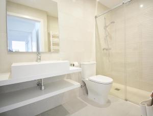 a bathroom with a toilet and a sink and a shower at Precioso apartamento con piscina en Sanxenxo in Sanxenxo +16 photos