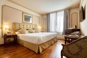 a hotel room with a large bed and a desk at Hotel Roger de Llúria in Barcelona