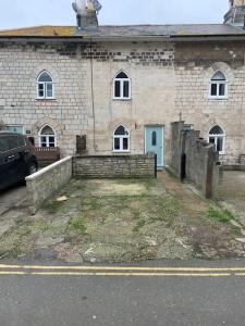 un edificio de ladrillo con un coche aparcado delante de él en Cozy Cottage 18th Century Seaside Escape Free parking, en Weymouth