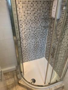 una ducha con puerta de cristal en un baño en Cozy Cottage 18th Century Seaside Escape Free parking, en Weymouth 12 fotos más