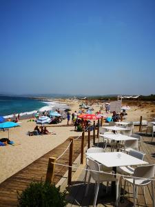 a beach with tables and chairs and people on the sand at Sardegna Stupenda N 01 in Aglientu
