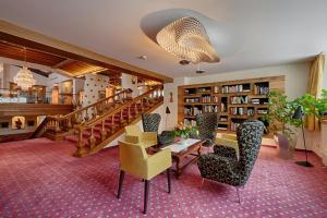 a library with chairs and a table and a staircase at Thermenwelt Hotel Pulverer in Bad Kleinkirchheim