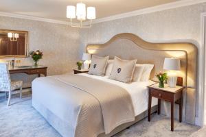 a bedroom with a large bed and a desk at Matfen Hall Hotel, Golf & Spa in Matfen
