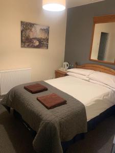 a bedroom with a bed with two towels on it at The Coach House at The Bull Inn in Milton Keynes