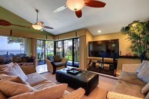 a living room with a couch and a flat screen tv at WAILEA ELUA, #1204 condo in Wailea
