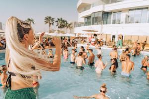 une femme debout dans l'eau à la piscine dans l'établissement FIVE Jumeirah Village, à Dubaï