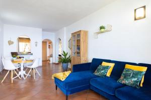 Home2Book Stunning Sea View Santa Úrsula في سانتا أورسولا: غرفة معيشة مع أريكة زرقاء وطاولة