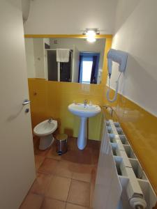 een badkamer met een wastafel, een toilet en een spiegel bij Hermitage Ravello in Ravello