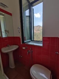 een badkamer met een toilet, een wastafel en een raam bij Hermitage Ravello in Ravello