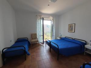 een slaapkamer met 2 bedden, een raam en een stoel bij Hermitage Ravello in Ravello