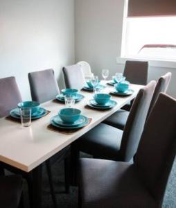 a dining room table with chairs and blue dishes on it at Cunninghame 2 in Beith