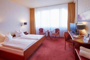 フロイデンシュタットにあるホテル トイヒェルヴァルトのベッドとテーブルが備わるホテルルームです。