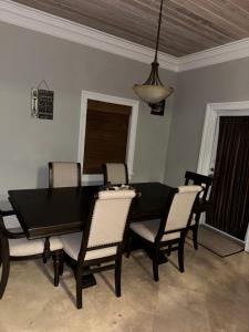 a dining room with a black table and chairs at Hidden Gem Exuma - KING BED master suite and central air in Georgetown